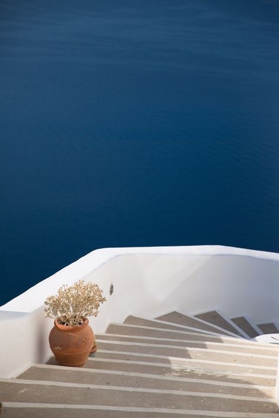 Una escalera blanca que sube bajo un cielo azul